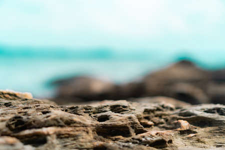 Selective focus od black stone texture for put product to show with beach in background.の写真素材