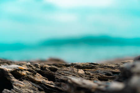 Selective focus od black stone texture for put product to show with beach in background.の写真素材