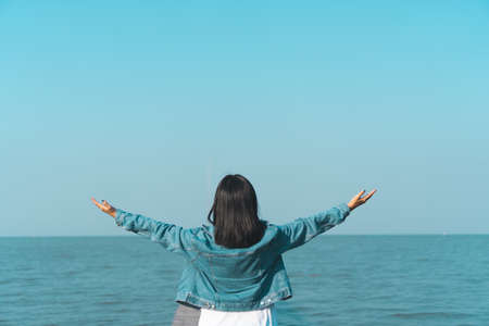 Woman rise hands up to sky freedom concept with blue sky and summer field background.の写真素材