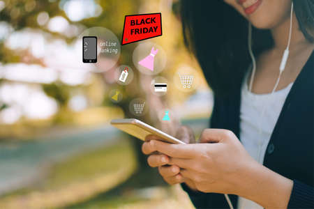 Women hand using smartphone do online selling for people shopping online in black friday with chat box, cart, dollar icons pop up. Social media maketing concept.の写真素材