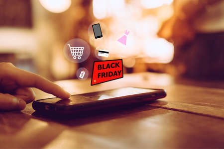 Women hand using smartphone do online selling for people shopping online in black friday with chat box, cart, dollar icons pop up. Social media maketing concept.の写真素材