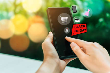 Women hand using smartphone do online selling for people shopping online in black friday with chat box, cart, dollar icons pop up. Social media maketing concept.の写真素材