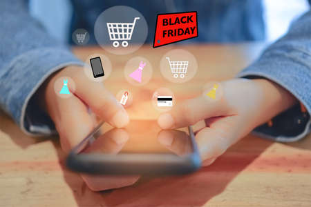 Women hand using smartphone do online selling for people shopping online in black friday with chat box, cart, dollar icons pop up. Social media maketing concept.の写真素材