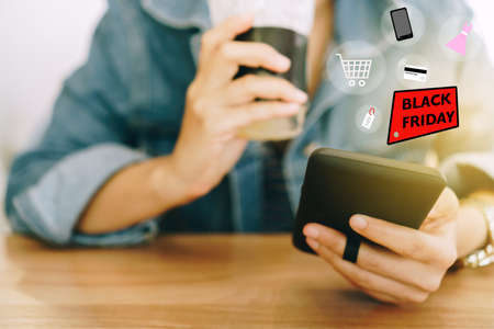 Women hand using smartphone do online selling for people shopping online in black friday with chat box, cart, dollar icons pop up. Social media maketing concept.の写真素材