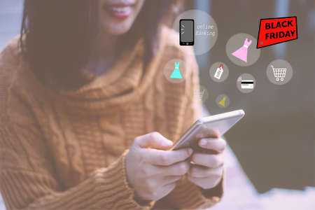 Women hand using smartphone do online selling for people shopping online in black friday with chat box, cart, dollar icons pop up. Social media maketing concept.の写真素材