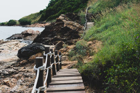 Wood small bridge walk way for sightseeing beside beach with green nature around background.の写真素材