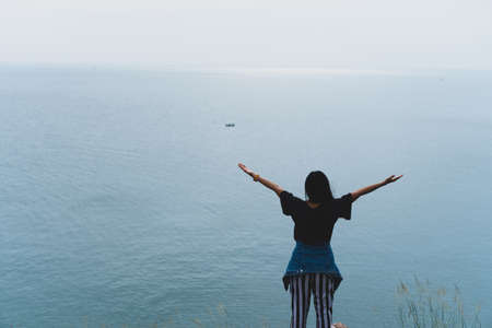 Woman rise hands up to sky freedom concept with blue sky and summer field background.の写真素材