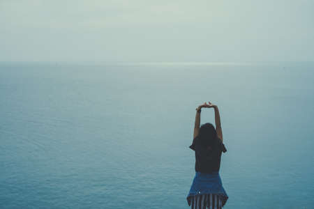 Woman rise hands up to sky freedom concept with blue sky and summer field background.の写真素材