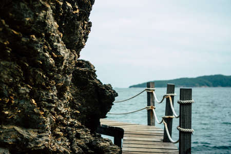 Wood small bridge walk way for sightseeing beside beach with green nature around background.の写真素材