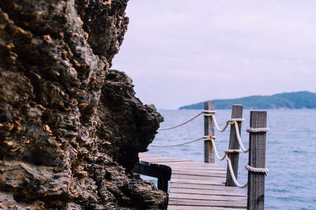 Wood small bridge walk way for sightseeing beside beach with green nature around background.の写真素材