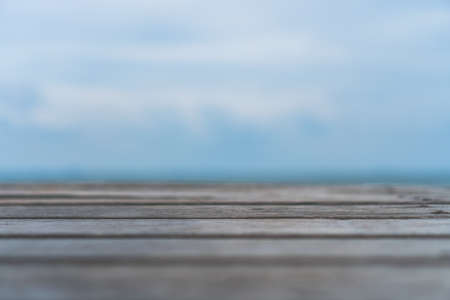 Selective focus of old wood table with blur beautiful beach background for display your product.の写真素材