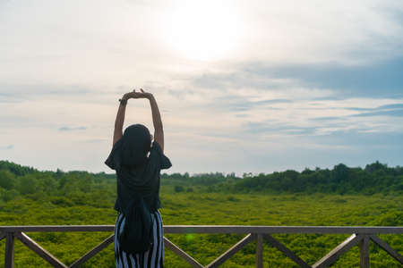 Woman rise hands up to sky freedom concept with blue sky and summer field background.の写真素材
