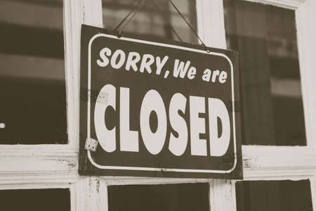 A Sign board of sorry we are closed hang on door of business shop with nature green backgroundの写真素材