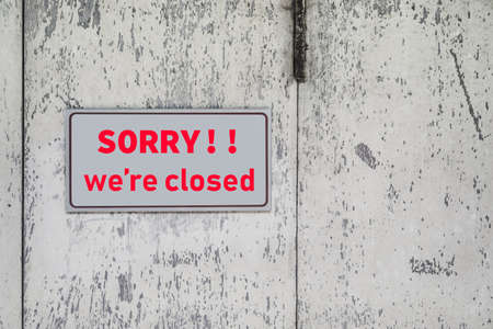 A Sign board of sorry we are closed hang on door of business shop with nature green backgroundの写真素材
