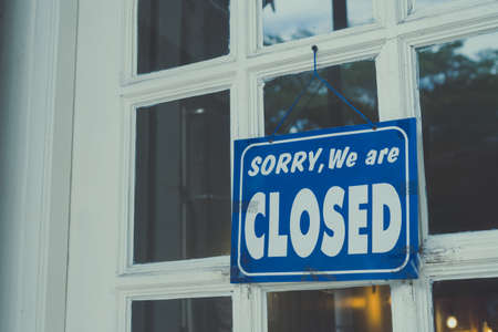 A Sign board of sorry we are closed hang on door of business shop with nature green backgroundの写真素材
