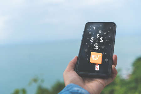 Women hand using smartphone do online selling for people shopping online in black friday with chat box, cart, dollar icons pop up. Social media maketing concept.の写真素材