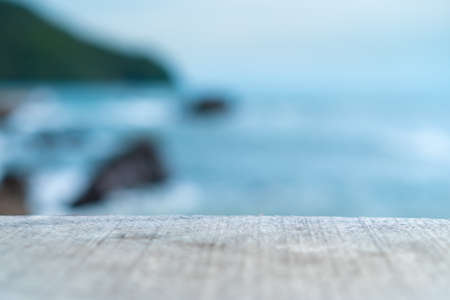 Selective focus of old wood table with blur beautiful beach background for display your product.の写真素材