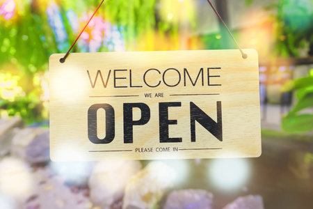 A business sign that says â€˜Openâ€™ on cafe or restaurant hang on door at entrance....
