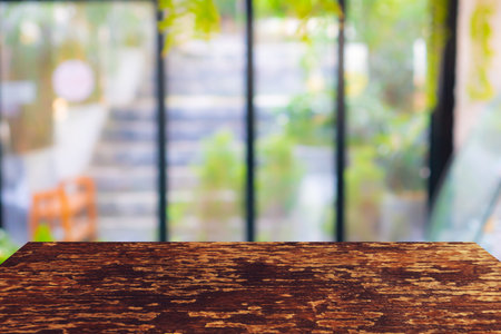 Blur coffee and restutant cafe with wood board in front background vintage tone color style.