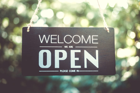 A business sign that says open on cafe or restaurant hang on door at entrance. Vintage color tone...