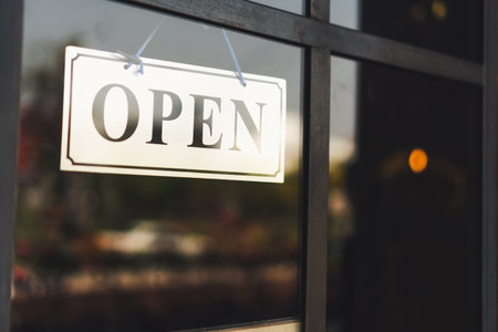A business sign that says â€˜Openâ€™ on cafe or restaurant hang on door at entrance....