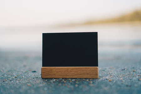 Dark small copy space of blackboard on  sand with beach background.の写真素材