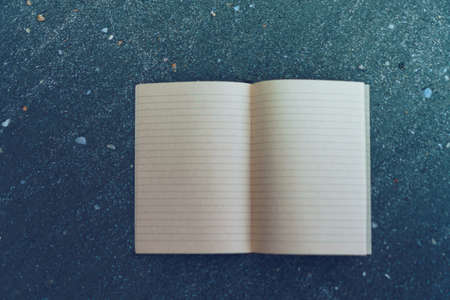 Small white notebook on sand at beautiful beach sea texture background.の写真素材