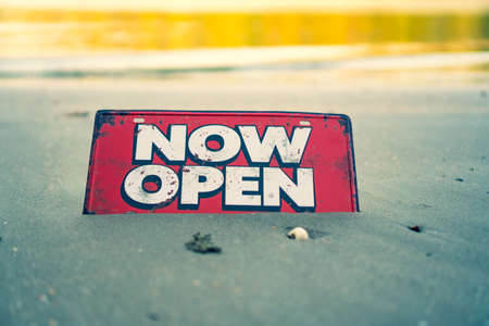 A business sign that says âOpenâ on sand at beautiful beach background.の写真素材