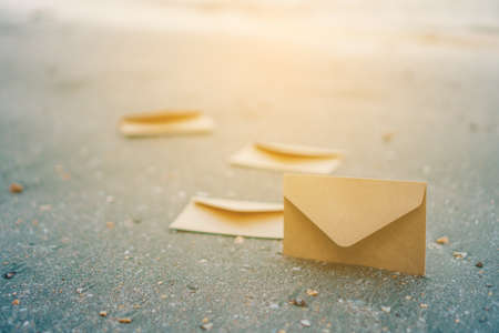 many od envelope imply for sending mail on sand texture background at beautiful beach.の写真素材