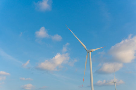 Wind energy converter as wind turbine ecology system clean power with blue sky background.