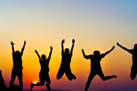A group of women rise hands up to sky freedom concept with blue sky and summer beach sunset background.の写真素材