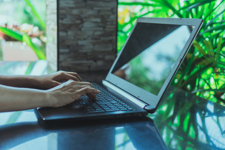 Woman hand using laptop and smartphone to work study with cafe shop colorful beautiful bokh...