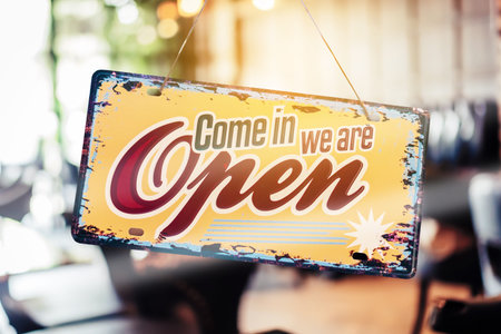 A business sign that says â€˜Openâ€™ on cafe or restaurant hang on door at entrance....