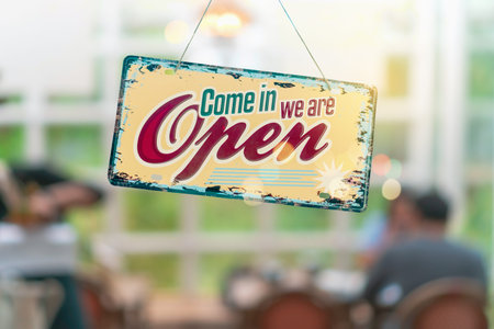 A business sign that says open on cafe or restaurant hang on door at entrance. Vintage color tone...