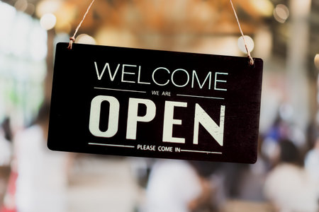 A business sign that says open on cafe or restaurant hang on door at entrance. Vintage color tone...