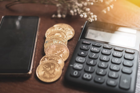 Calculator and a stack of Bitcoins coins as symbol of cryptocurrency digital money in the future...