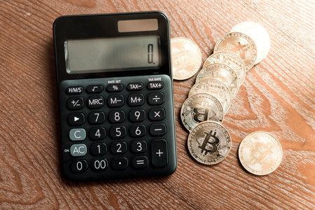 Calculator and a stack of Bitcoins coins as symbol of cryptocurrency digital money in the future blockchain. Wealth rich investment concept.の写真素材