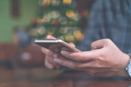 Woman hand using smartphone in cafe shop background. Business, financial, trade stock market and social network concept.の写真素材