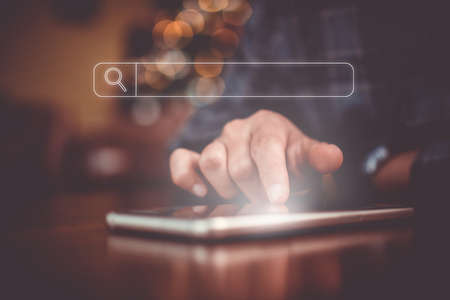 People hand using mobile phone or smartphone searching for information in internet online society web with search box icon and copyspace.の写真素材