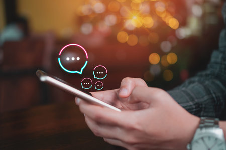 People hand using smartphone typing, chatting or text  messages in chat icons pop up. Social media...