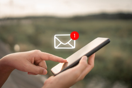 Woman hand use smartphone in public area with 1 new email alert sign icon pop up. Communication business technology concept.の写真素材