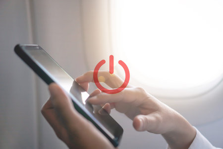 Woman hand use smartphone in airplane with turn off or switch off sign icon during flight.Work and...