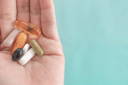 Top view of alternative organic medicine or herbal vitamin supplement capsule tablet on woman hand with copyspace background. Concept of healthy eating lifestyle.の写真素材