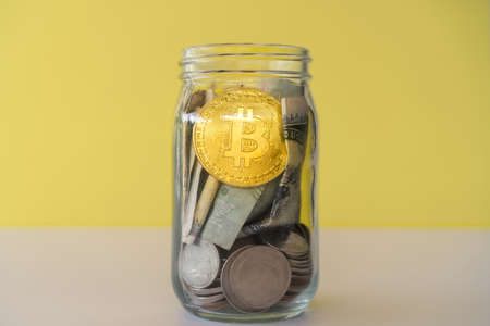 Bitcoin the jar full of coin and bank notes meaning of saving investment with cryptocurrency digital money fintech online network. Business technology concept.の写真素材