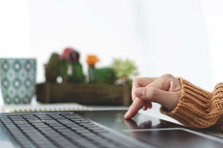 Woman hand using laptop or smartphone to work study on work desk with clean nature background background. Business, financial, trade stock market and social network concept.の写真素材