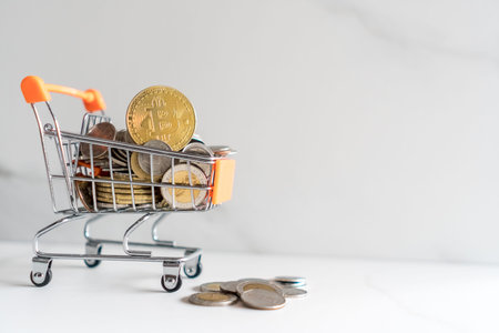 Bitcoin or cryptocurrency symbol in mini cart model full of coins money with copyspace white...
