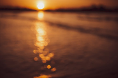 Blur beach with bokeh orange sunset theme color background.