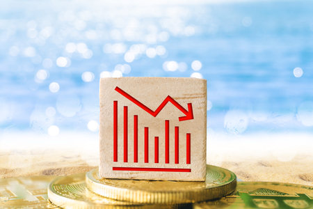 Graph chart going down bearish sign on wooden cube with objects such as gold coin, calculator and...