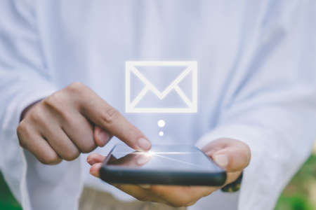 Woman hand use smartphone in public area with 1 new email alert sign icon pop up. Communication business technology concept.の写真素材