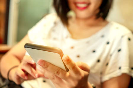 Woman hand use smartphone to do work business, social network, communication in public cafe work space area.の写真素材